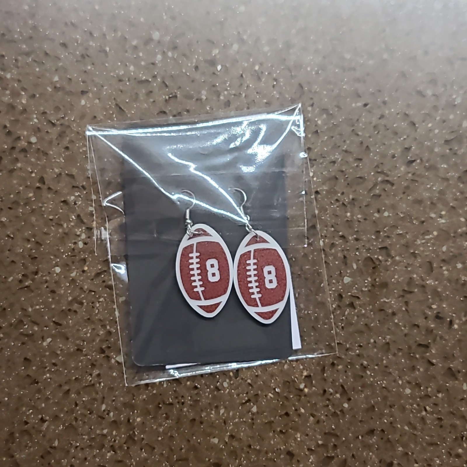 Personalized football earrings packaged on a display card